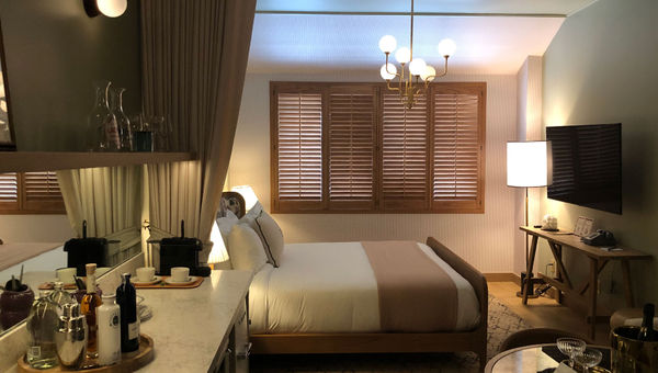 A room at Palihouse Hyde Park Village features green and beige decor and plantation shutters. A room at Palihouse Hyde Park Village features green and beige decor and plantation shutters.